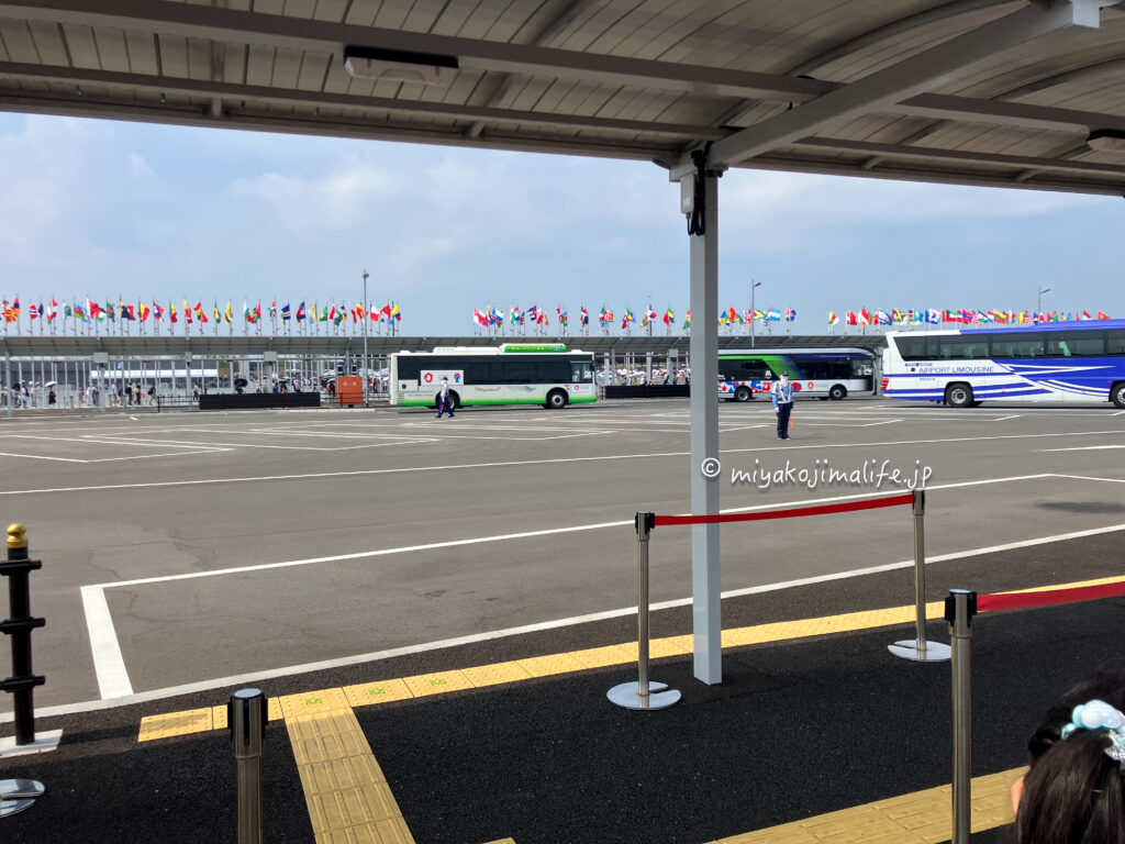 大阪関西万博西側ゲート。バスと国旗が並んでいる。